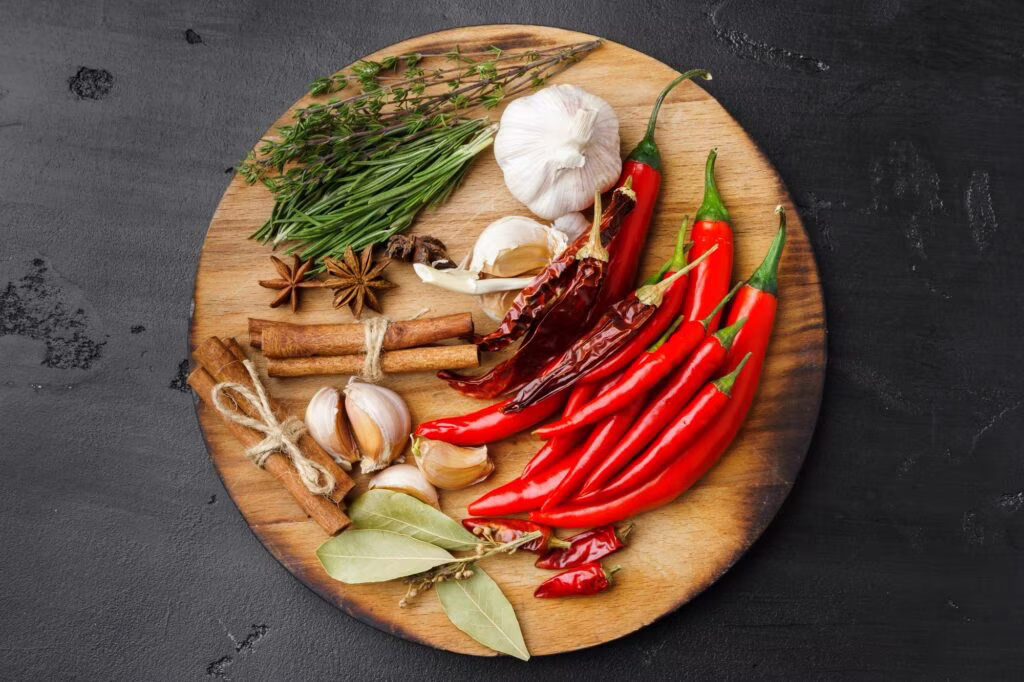 Garlic cloves and spices on black background
